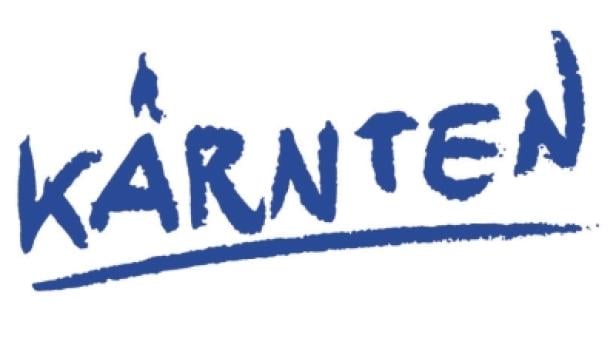 This is a logo or text design for "KÄRNTEN" (Carinthia in English), which appears to be written in bold blue letters with a brushstroke or hand-drawn style. There's a small bird-like figure above the text, which is likely a reference to Carinthia, a state in southern Austria known for its mountains and lakes.