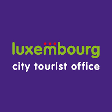 This is the logo for the Luxembourg City Tourist Office featuring simple text in two colors. The words "luxembourg" appear in a bright lime green color while "city tourist office" is written in white, all set against a deep purple background in a clean, modern design.